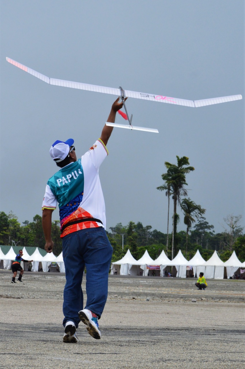 Pelatih Tim Aeromodeling Papua, David Gunawan saat melepaskan pesawat miniatur yang ditarik oleh Atlet Papua, Nanik Novianti dalam pertandingan F1.A (Glider Tarik A2) putri di Venue Aeromodeling SP-5 Timika, Selasa (5/10/2021). (Foto: Lukas Tandilimbong/Humas PPM)