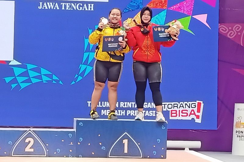 Lifter asal Jawa Tengah Diah Ayu Permatasari berbagi podium dengan atlet asal Lampung Yuliani Gena usai meraih kemenangan di angkat besi putri PON XX Papua, Jumat (8/10/2021)