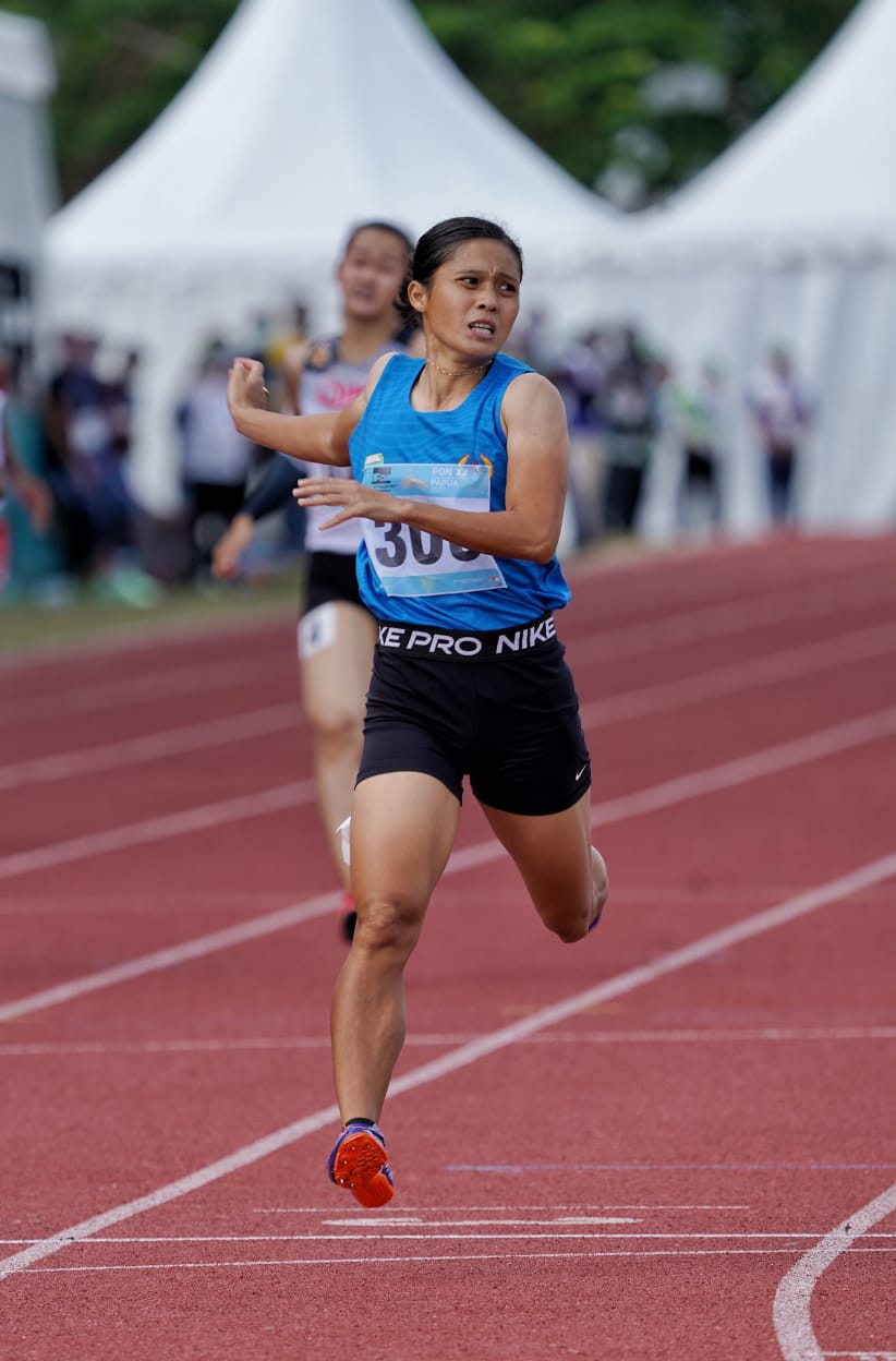 306 Sri Mayasari asal Sumatera Selatan (biru) berhasil meraih medali emas di nomor lari 400 meter putri PON XX Papua yang digelar di arena atletik Mimika Sport Complex, Selasa (12/10/2021). Foto: Humas PPM/Fernando Rahawarin