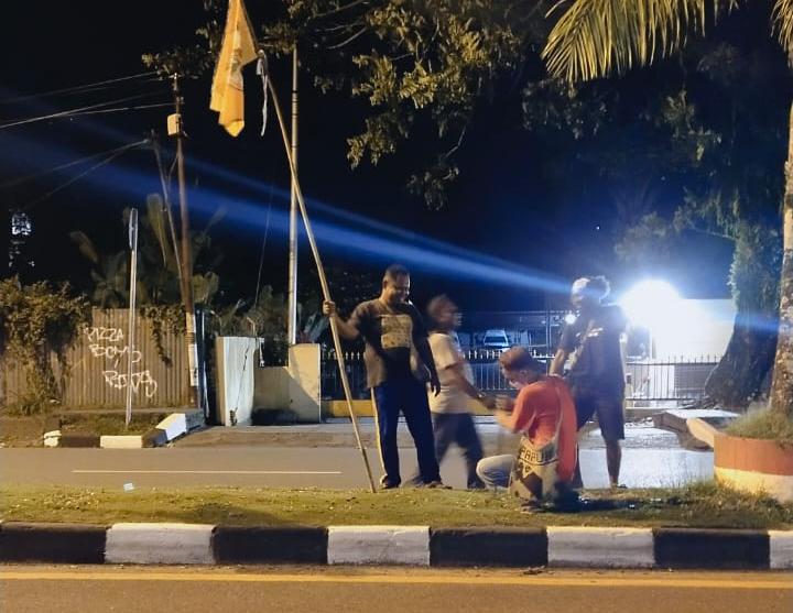 Seksi dokumentasi dan publikasi Pesparawi XIII seTanah Papua memasang umbul-umbul di median jalan pada Kamis malam.