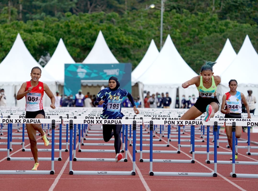 KETERANGAN FOTO : Emilia Nova persembahkan medali emas di nomor 100 meter lari gawang untuk DKI Jakarta pada Pekan Olahraga Nasional (PON) XX Papua di arena atletik Mimika Sport Complex, Selasa (5/10/2021). Humas PPM/Fernando Rahawarin