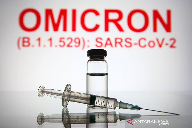 Jarum suntik medis dan botol terlihat di depan teks Omicron (B.1.1.529): SARS-CoV-2 di latar belakang.