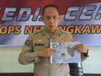 Kasatgas Humas Ops Nemangkawi Kombes Pol Drs Ahmad Musthofa Kamal SH sedang menunjuk foto barang bukti yang diamankan.