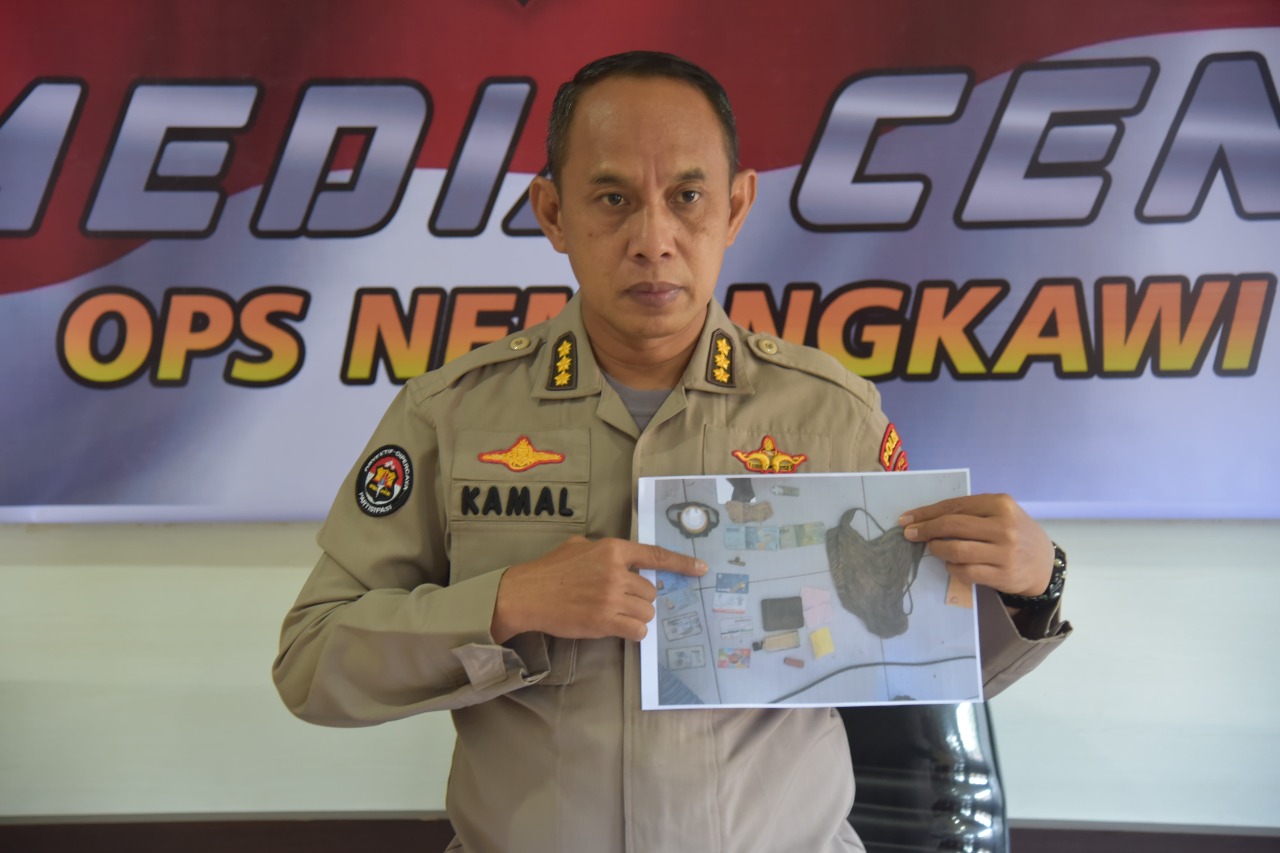 Kasatgas Humas Ops Nemangkawi Kombes Pol Drs Ahmad Musthofa Kamal SH sedang menunjuk foto barang bukti yang diamankan.