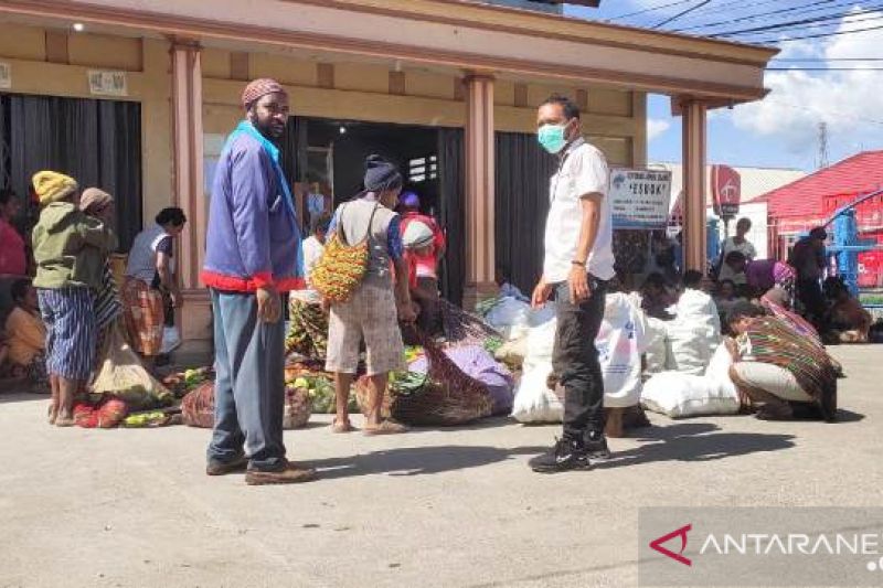 Dua petugas Disnakerindag Jayawijaya yang membantu mama Papua yang membawa sayur mayur ke Koperasi Pemda Jayawijaya untuk dijual ke Mimika.