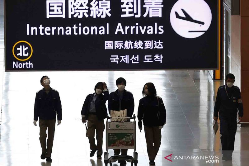 Orang-orang berjalan di lobi kedatangan penerbangan internasional di Bandara Kansai, Prefektur Osaka, Jepang, Selasa (30/11/2021).