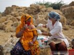 Jabuben Bharwad, 30 tahun, menerima dosis vaksin COVISHIELD, vaksin penyakit virus corona (COVID-19) yang diproduksi oleh Serum Institute of India, saat bekerja di lapangan saat program vaksinasi dari pintu ke pintu di Desa Mahijada, pinggiran Kota Ahmedabad, India, Rabu (15/12/2021).