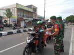 Personel TNI Koramil Mimika Pelda Mustajib memberikan edukasi prokes pengguna jalan dan membagikan masker.