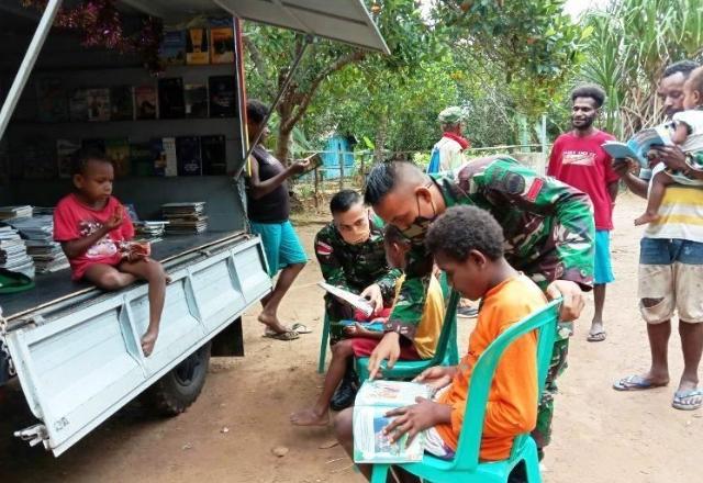 Anak-anak asli Papua di Sota Kabupaten Merauke wilayah perbatasan RI-PNG sedang menikmati layanan perpustakaan keliling yang disediakan Satgas TNI untuk meningkatkan kualitas sumber daya milenial Papua. 