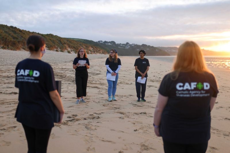 Aktivis dari Crack the Crisis mengadakan renungan untuk orang seluruh dunia yang meninggal dunia akibat penyakit virus korona (COVID-19) di sela-sela konferensi tingkat tinggi G7, di pantai Porthkidney di dekat Carbis Bay, Cornwall, Britain, Jumat (11/6/2021)