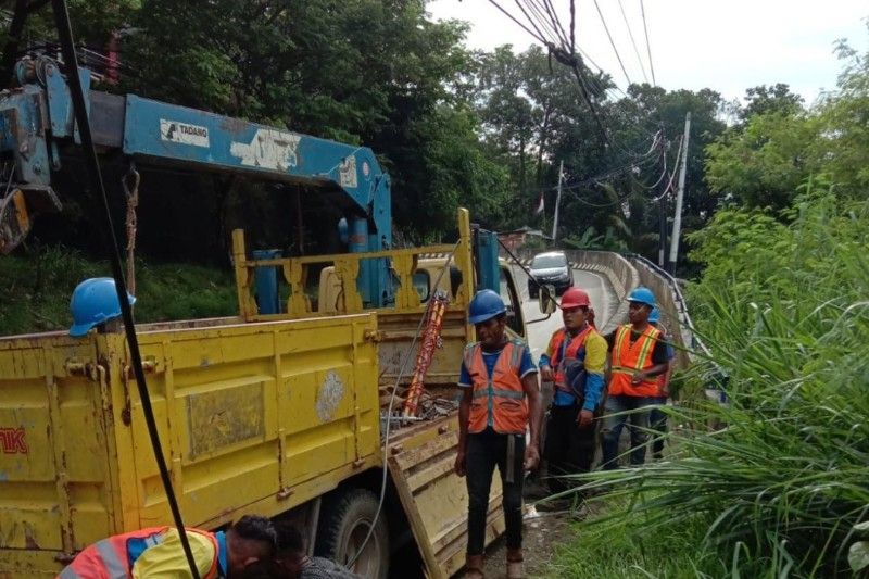 Petugas PT PLN (Persero) sedang memperbaiki kabel listrik yang terdampak banjir di Jayapura, Papua.