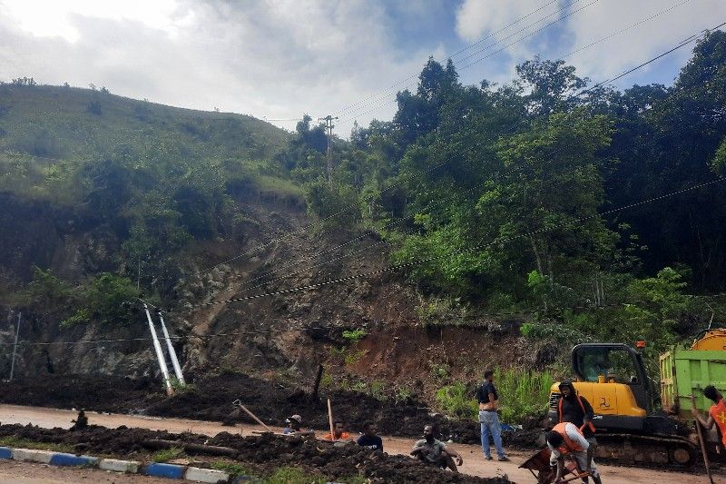 Petugas membersihkan sisa banjir dan longsor Kamis (6/1) di jalan menuju Kabupaten Jayapura