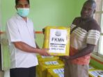 Ahmad Darji Difinubun menyerahkan bantuan dari FKMN Mimika yang diterima kepala kampung Atuka.