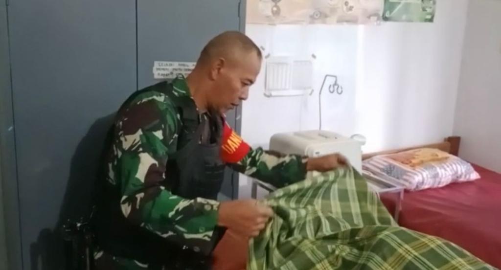 Anggota TNI menjenguk korban yang tewas tertembak.