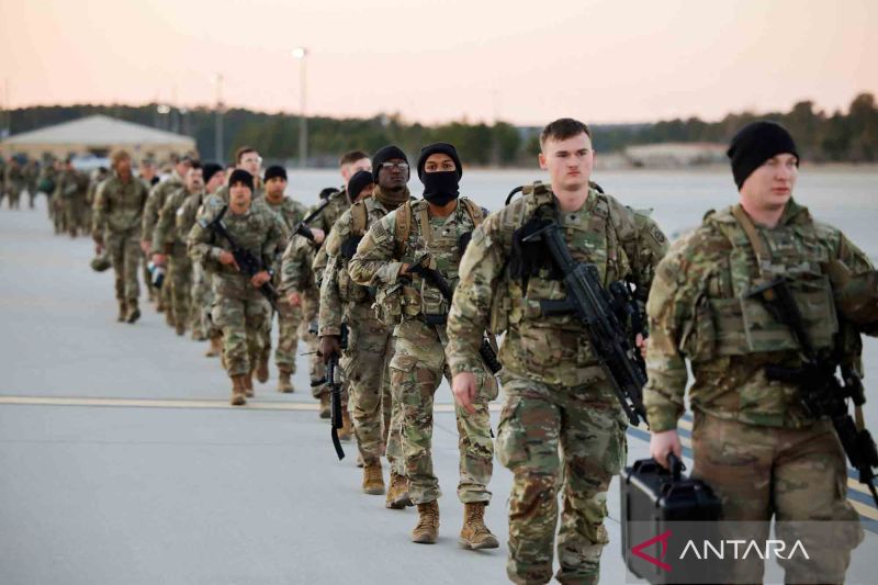 Tentara Angkatan Darat Amerika Serikat Divisi Airborne ke-82 berjalan menuju pesawat udara yang akan bertolak ke Eropa Timur di Fort Bragg, Carolina Utara, Amerika Serikat, Senin (14/2/2022).