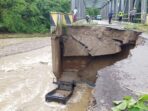 Satu unit mobil bak terbuka yang terjun bebas ke sungai di Jembatan Mowou Wasior, Kabupaten Teluk Wondama, akibat jalan longsor.