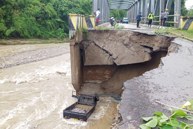 Satu unit mobil bak terbuka yang terjun bebas ke sungai di Jembatan Mowou Wasior, Kabupaten Teluk Wondama, akibat jalan longsor.