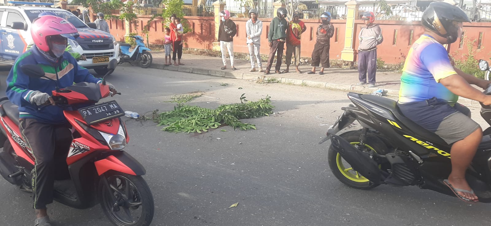 Warga menutupi darah yang berlumuran di jalan raya