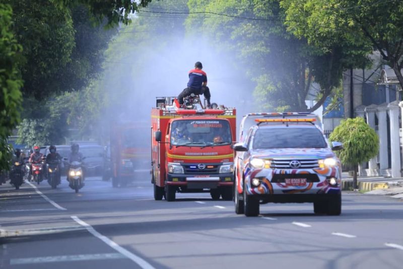 Petugas menyemprotkan cairan disinfektan menggunakan mobil pemadam kebakaran di fasilitas umum Kota Madiun, Jawa Timur, Rabu (2/2/2022) guna mewaspadai penularan COVID-19, utamanya varian Omicron.