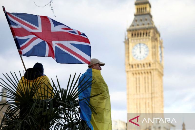 Seorang demonstran memegang bendera Inggris saat memprotes invasi Rusia ke Ukraina, di kompleks parlemen di London, Inggris, 6 Maret 2022.