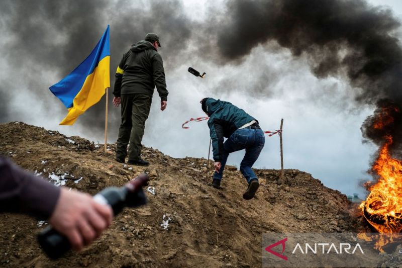 Seorang warga sipil berlatih melempar bom molotov untuk mempertahankan kota ketika invasi Rusia ke Ukraina terus berlanjut, di Zhytomyr, Ukraina, 1 Maret 2022.