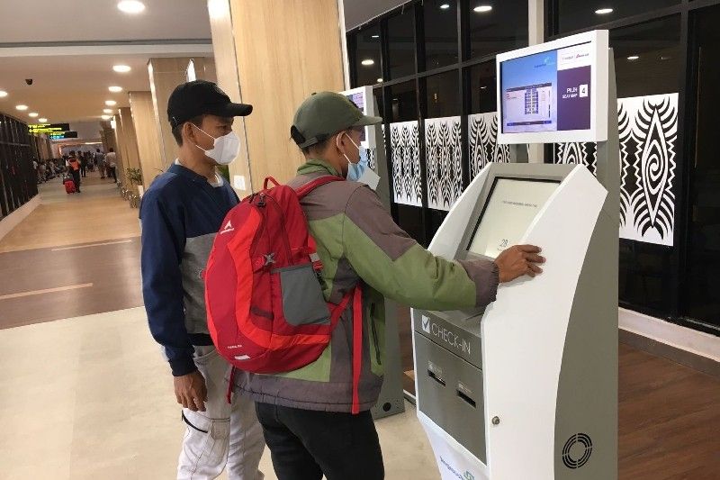 Calon penumpang di Bandara Sentani, Papua, menggunakan mesin check in mandiri.