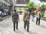Foto: HSB Naftali atau Zakheus Keroman (kiri) melangkah mantap menuju Rektorat STAKPN Sentani didampingi Danramil Jayapura.