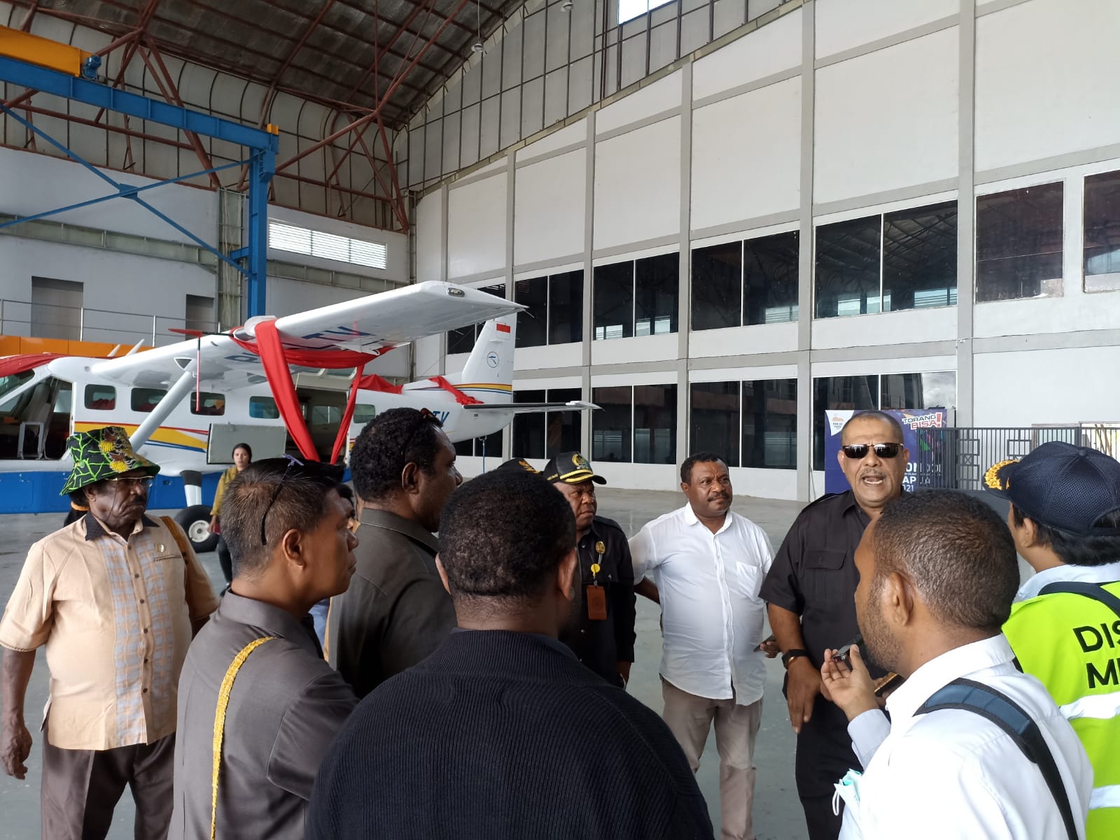 Foto: Febri Sekretaris Komisi C DPRD Mimika, Saleh Alhamid bersama anggota rombongan saat berada di hanggar dengan latar pesawat Cessna Grand Caravan PK-LTV milik Pemda Kabupaten Mimika.